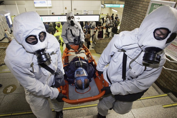 SAITAMA, JAPAN - NOVEMBER 17: Men in chemical protection suits carry an injured person during a joint anti-terrorism drill conducted by Japan Ground Self-Defense Force, Police and Fire Department at Onomiya Station on November 17, 2005 in Saitama City, Saitama Prefecture, North of Tokyo, Japan. The drill conducted amid increased terrorism concerns was based on the scenario of a sarin nerve gas attack at a station. (Photo by Junko Kimura/Getty Images)