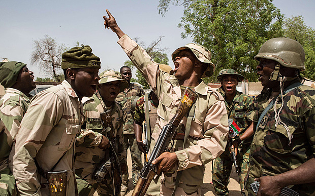 TOPSHOTS Nigerian troops celebrate after taking over Bama from Boko Haram on March 25, 2015. Nigeria's military has retaken the northeastern town of Bama from Boko Haram, but signs of mass killings carried out by Boko Haram earlier this year remain.  AFP PHOTO / NICHOLE SOBECKINichole Sobecki/AFP/Getty Images