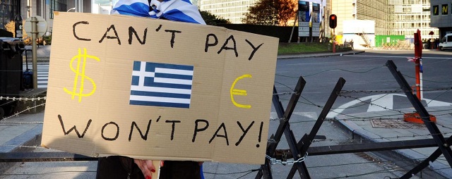 A Protestor holds a placard with a Greek flag during a demonstration outside of an EU summit in Brussels on Sunday, Oct. 23, 2011. Greece's prime minister George Papandreou is pleading with European leaders in Brussels to act decisively to solve the continent's debt crisis. At a summit Sunday, the leaders are expected to ask banks to accept huge losses on Greek bonds to ease the pressure on the country, and to raise billions more in capital to weather those losses. (AP Photo/Geert Vanden Wijngaert)