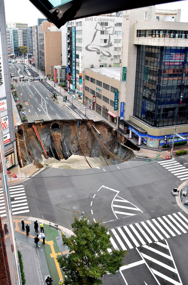 A huge sinkhole is seen at an intersection near Hakata station in Fukuoka, Japan, November 8, 2016 in this photo taken by Kyodo.  Mandatory credit Kyodo/via REUTERS ATTENTION EDITORS - THIS IMAGE WAS PROVIDED BY A THIRD PARTY. EDITORIAL USE ONLY. MANDATORY CREDIT. JAPAN OUT. NO COMMERCIAL OR EDITORIAL SALES IN JAPAN.