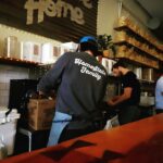 Εθελοντές σε χώρο διανομής τροφίμων ως συμβολική εικόνα για το Lighthouse Food Rescue